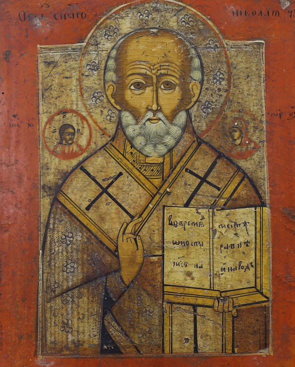 19th century South Russian School, tempera on wooden panel, Icon of St. Nicholas holding the scripture and giving a benediction, 28 x 22cm, unframed